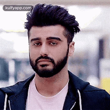 A Man With A Beard And A Pink Shirt Is Wearing A Black Jacket And A Pink Shirt . GIF