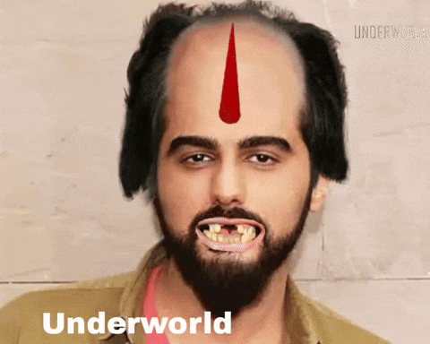A Man With A Beard And A Red Arrow On His Forehead Has Underworld Written On The Bottom Of His Face GIF