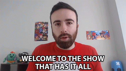 A Man With A Beard And A Red Shirt Says " Welcome To The Show That Has It All " GIF