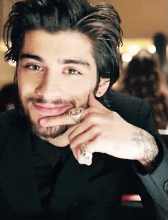 A Man With A Beard And A Ring On His Finger Smiles GIF