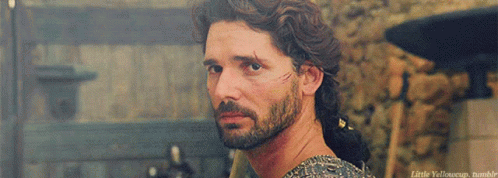 A Man With A Beard And A Scar On His Face Is Looking Over His Shoulder At Something GIF