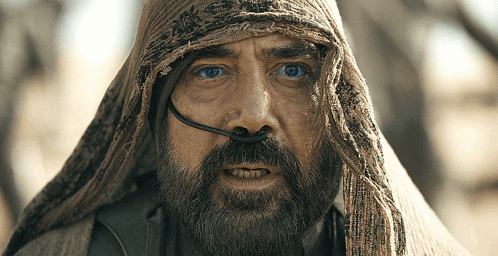A Man With A Beard And A Scarf Around His Head Looks At The Camera GIF