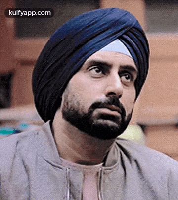 A Man With A Beard And A Turban On His Head Is Looking Up . GIF