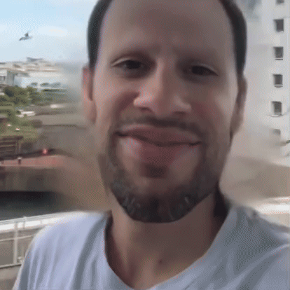 A Man With A Beard And A White Shirt Is Smiling GIF