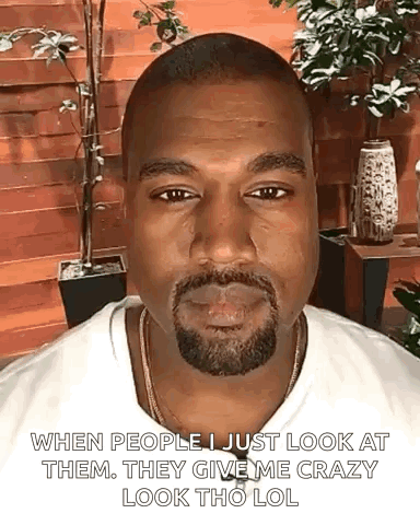 A Man With A Beard And A White Shirt Is Smoking A Cigarette And Making A Funny Face . GIF