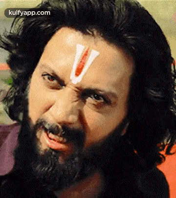 A Man With A Beard And A White V On His Forehead . GIF