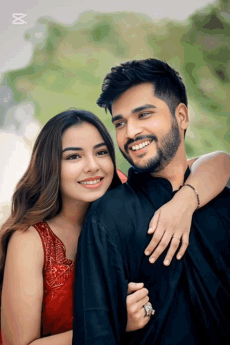 A Man With A Beard And A Woman In A Red Dress Are Posing For A Picture GIF