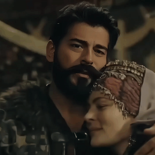 A Man With A Beard And A Woman Wearing A Head Scarf GIF