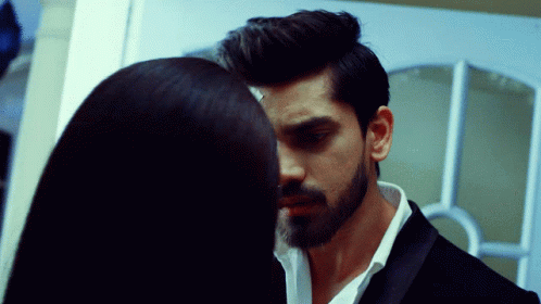 a man with a beard and a woman with long hair are looking into each other 's eyes
