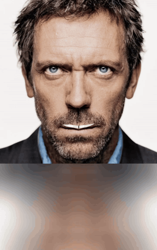 A Man With A Beard And Blue Eyes Is Looking At The Camera GIF