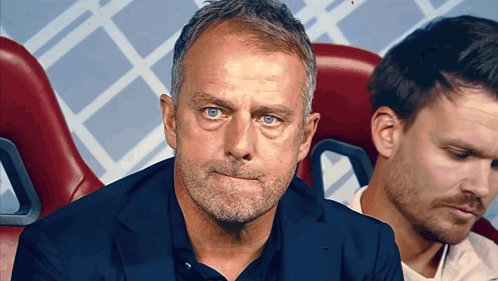 A Man With A Beard And Blue Eyes Is Sitting In A Chair GIF
