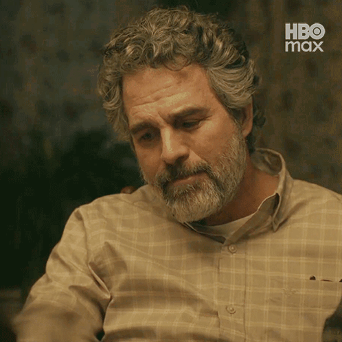 A Man With A Beard And Curly Hair Is Wearing A Plaid Shirt With Hbo Max On The Bottom GIF