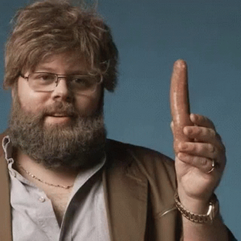 A Man With A Beard And Glasses Is Holding A Sausage In His Hand GIF