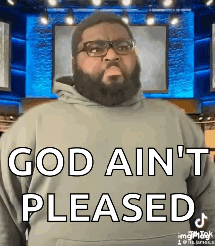 A Man With A Beard And Glasses Is Standing In Front Of A Blue Screen And Says God Ain 'T Pleased GIF