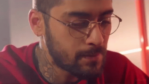 A Man With A Beard And Glasses Is Wearing A Red Shirt And A Red Shirt . GIF