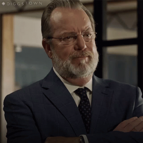 A Man With A Beard And Glasses Is Wearing A Suit And Tie With The Hashtag #Diggstown GIF