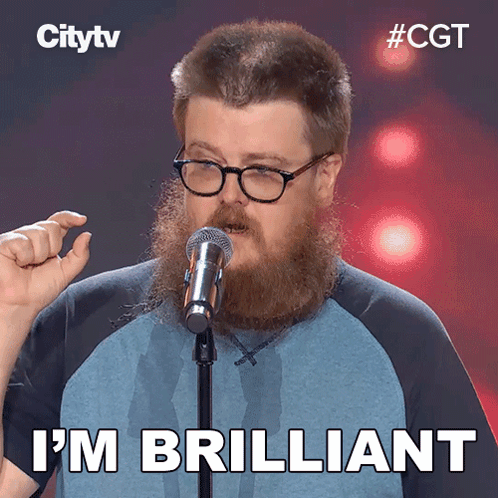 A Man With A Beard And Glasses Stands In Front Of A Microphone And Says " I 'M Brilliant " GIF