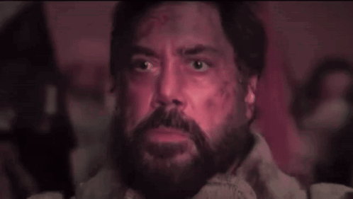 A Man With A Beard And Glowing Eyes Is Looking Up At Something . GIF