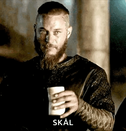 A Man With A Beard And Mustache Is Holding A Cup Of Coffee . GIF