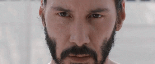 A Man With A Beard And Mustache Is Looking At The Camera GIF