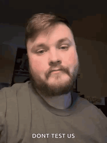 A Man With A Beard And Mustache Is Making A Funny Face And Says Do N't Test Us . GIF