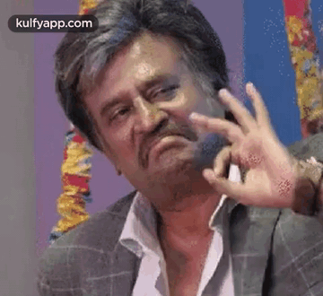 A Man With A Beard And Mustache Is Making A Funny Face With His Hands . GIF
