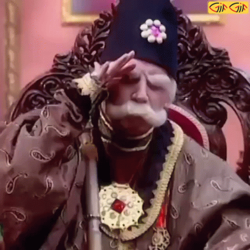 A Man With A Beard And Mustache Is Sitting In A Chair With His Hand On His Face . GIF