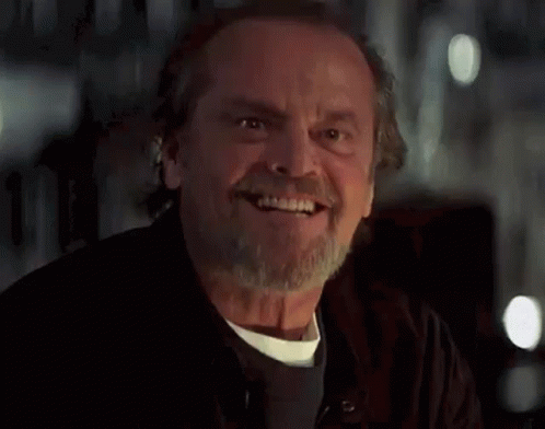 A Man With A Beard And Mustache Is Smiling And Looking At The Camera . GIF