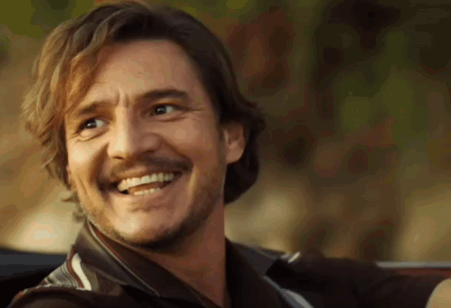 A Man With A Beard And Mustache Is Smiling And Looking At The Camera . GIF