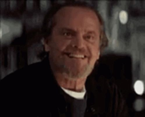 A Man With A Beard And Mustache Is Smiling And Looking At The Camera . GIF