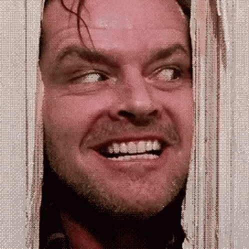 A Man With A Beard And Mustache Is Smiling While Looking Through A Window . GIF