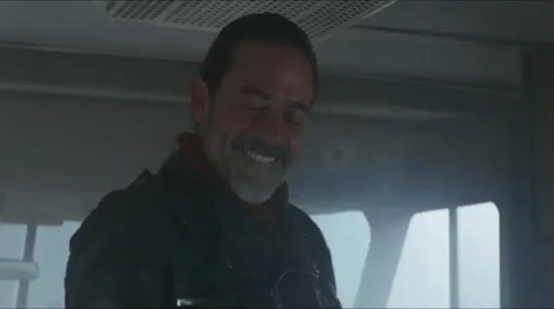A Man With A Beard And Mustache Is Smiling While Sitting In A Car . GIF