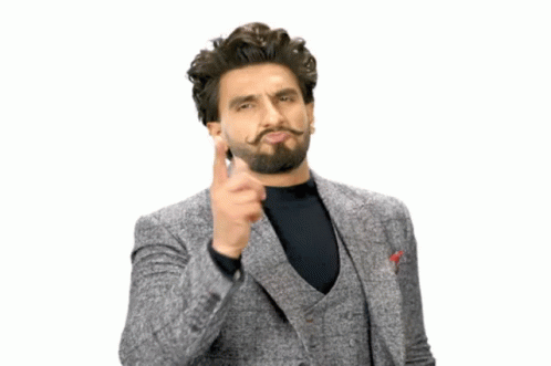 A Man With A Beard And Mustache Is Wearing A Grey Suit And Black Shirt GIF