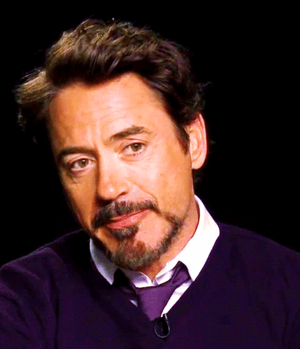 A Man With A Beard And Mustache Is Wearing A Purple Sweater And Tie GIF