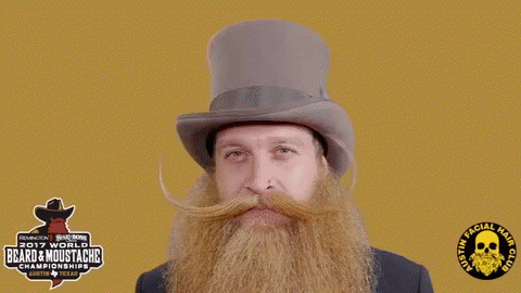 A Man With A Beard And Mustache Is Wearing A Top Hat Sponsored By The 2017 World Beard & Moustache Championship GIF