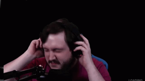 A Man With A Beard And Mustache Is Wearing Headphones In Front Of A Microphone . GIF