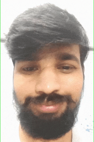 A Man With A Beard And Mustache Looks At The Camera GIF