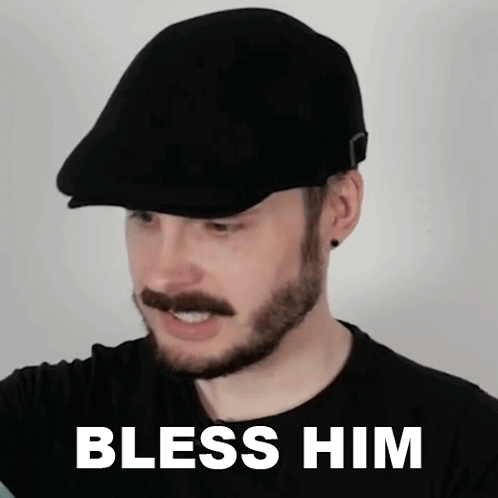 A Man With A Beard And Mustache Wearing A Flat Cap With The Words Bless Him On The Bottom GIF
