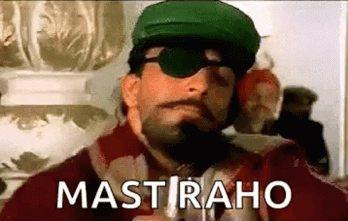 A Man With A Beard And Mustache Wearing Sunglasses And A Green Hat Is Smoking A Cigarette . GIF