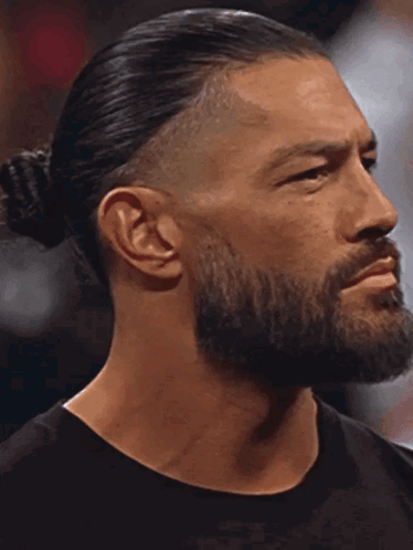 A Man With A Beard And Ponytail Is Looking At The Camera With His Eyes Closed GIF