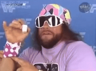 A Man With A Beard And Sunglasses Is Wearing A Purple Shirt And A Pink Hat . GIF
