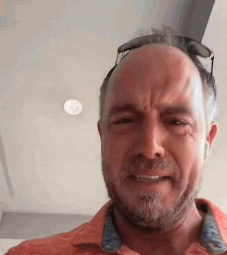 A Man With A Beard And Sunglasses On His Head Is Making A Funny Face . GIF