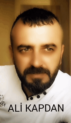A Man With A Beard And The Name Ali Kapdan On The Bottom Right GIF