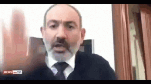 A Man With A Beard And Tie Is Talking On A Video Call With News Tv . GIF