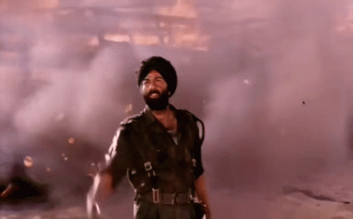 A Man With A Beard And Turban Is Standing In A Smokey Room GIF