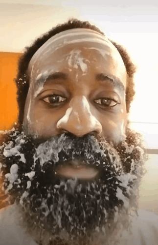 A Man With A Beard Covered In Foam Looks At The Camera GIF