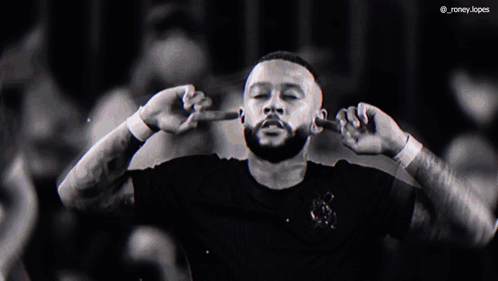 a man with a beard covering his ears with his hands