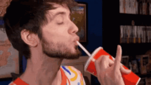 A Man With A Beard Drinking From A Red Cup With A Straw GIF