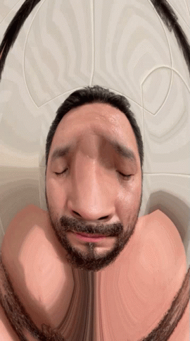 A Man With A Beard Has His Eyes Closed And Looks Like He Is Making A Funny Face GIF