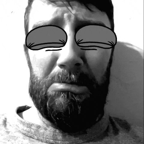 A Man With A Beard Has His Eyes Closed In A Black And White Photo GIF